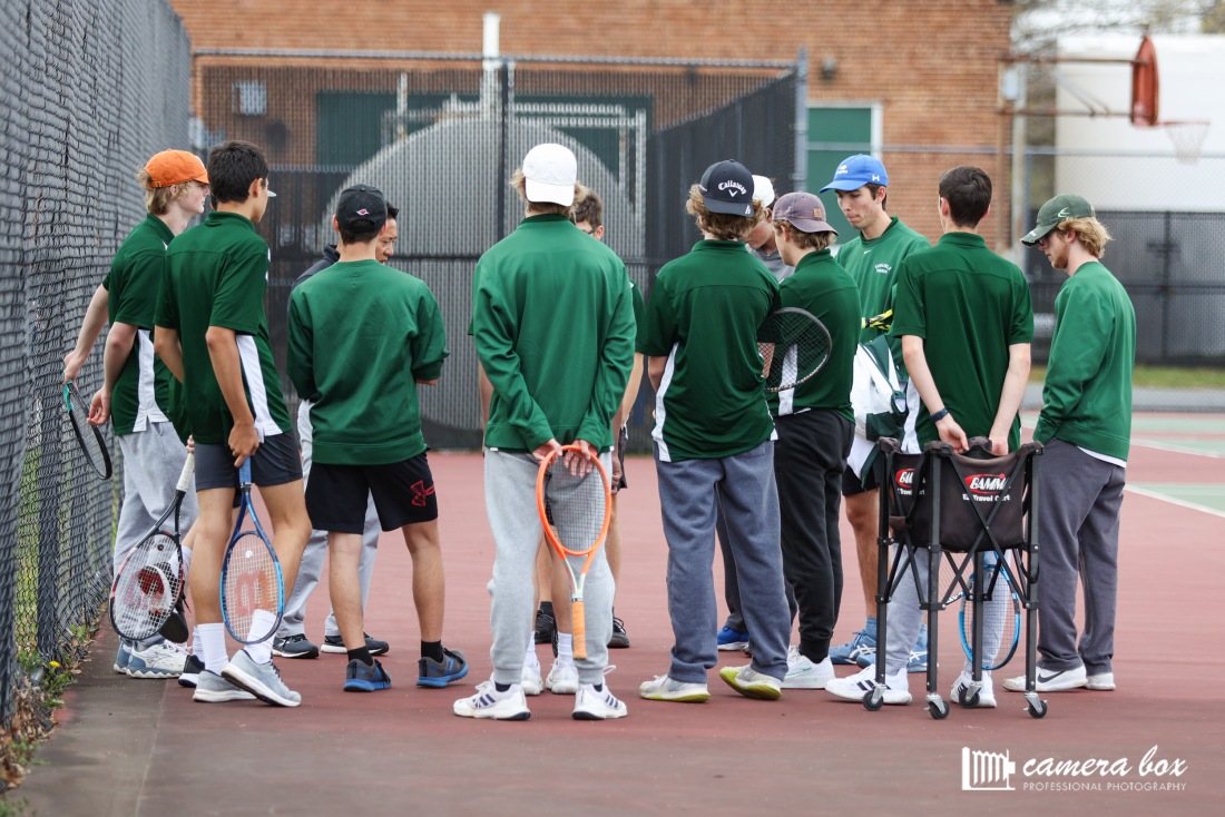 READY TO SERVE: The boys huddle up with Coach Pham before their match