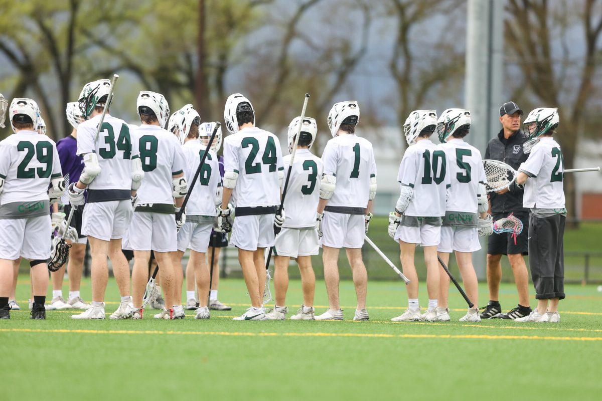 The boys lacrosse team stand on the sidelines before their game begins.